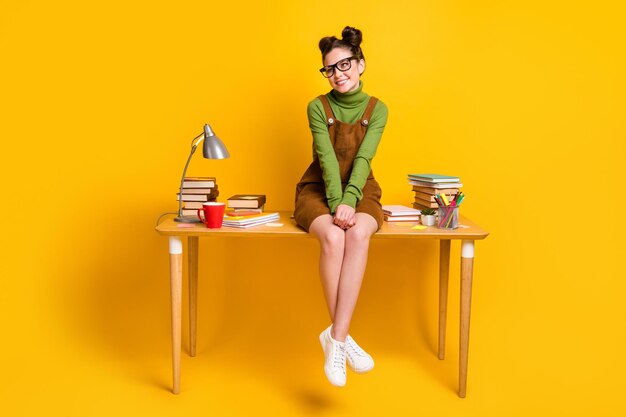 Full length photo of positive cheerful girl sit table look copyspace enjoy education courses day