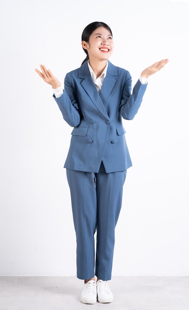 Full length photo of young Asian business woman on background