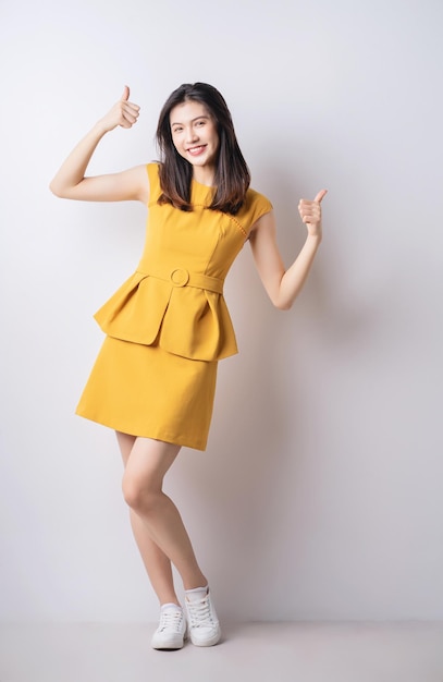 full length photo of young asian woman standing on white background