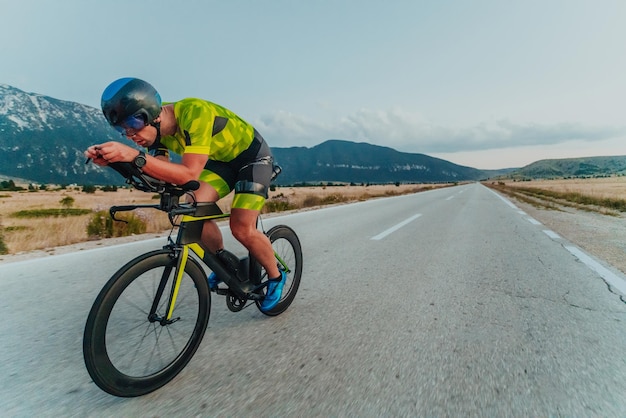 スポーツウェアを着て、保護ヘルメットをかぶって自転車に乗るアクティブなトライアスリートの全身ポートレート。選択と集中。