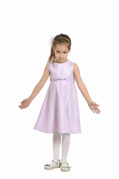 Full length portrait of an adorable little girl with pink dress standing over white background
