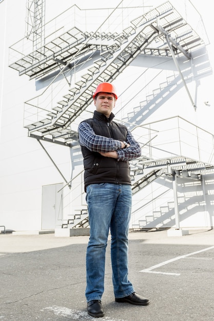 Full length portrait of architect posing against metal construction