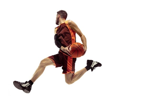 Photo full length portrait of a basketball player with ball isolated on white background. advertising concept. fit caucasian athlete jumping at studio. motion, activity, movement concepts.