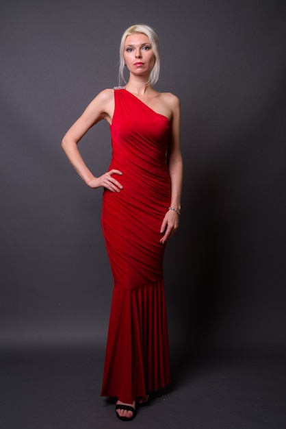 빨간 드레스를 입고 금발 머리를 가진 아름 다운 여자의 전체 길이 초상화