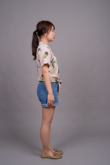 Full length portrait of beautiful young Asian woman standing