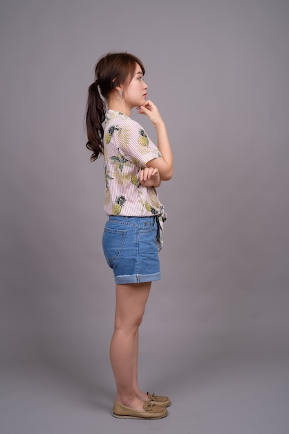 Full length portrait of beautiful young Asian woman standing