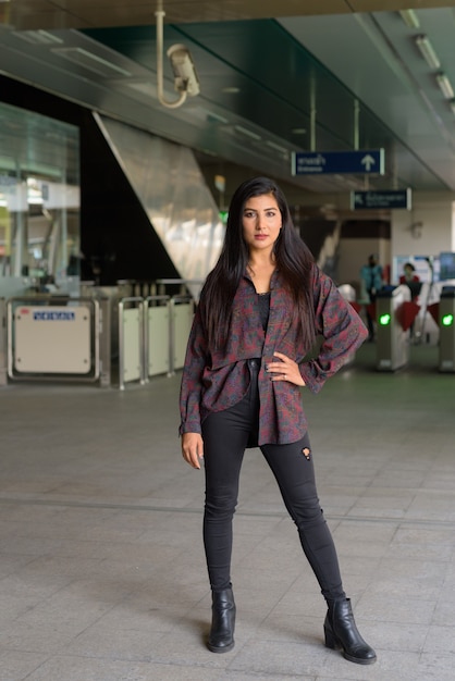 Full length portrait of beautiful young woman standing outdoors