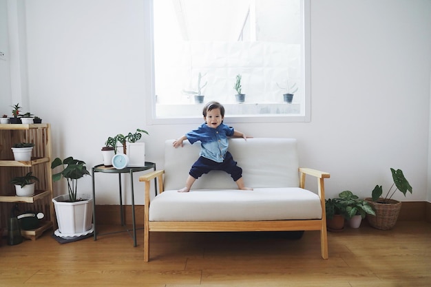 自宅のソファに座っている男の子の長さの肖像画
