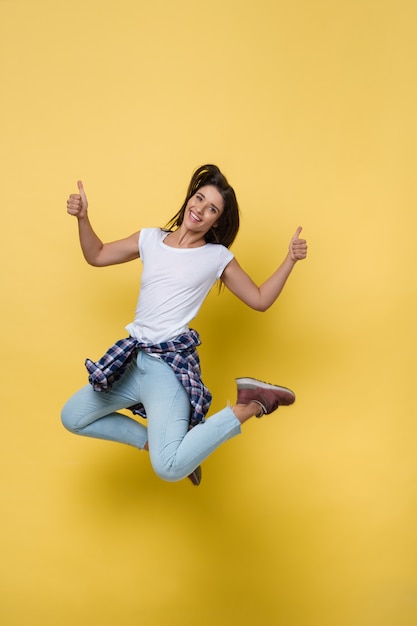 Full length portrait of a cheerful casual caucasian woman jumping 