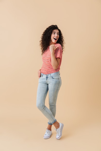 Full length portrait of a cheerful young woman