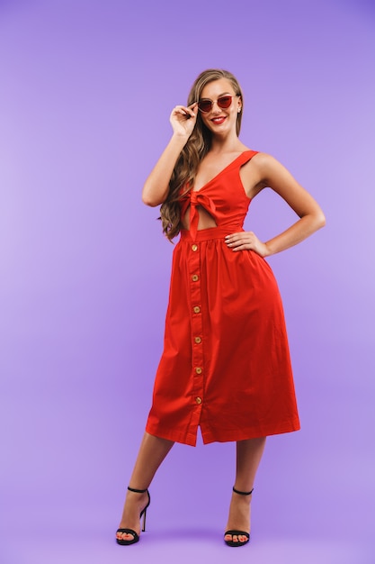 Full length portrait of content pretty woman wearing red dress smiling