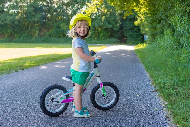 Foto ritratto a tutta lunghezza di un ragazzo carino con una bicicletta in piedi sulla strada