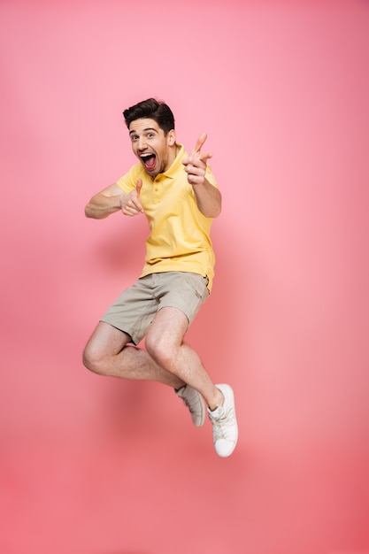 Full length portrait of an excited young man jumping