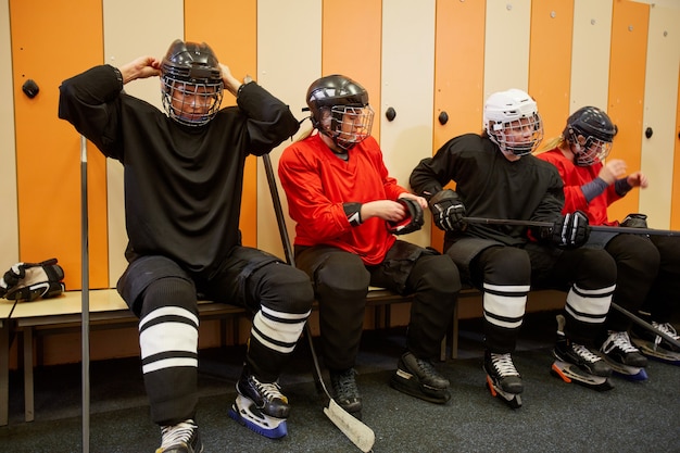 Foto ritratto integrale della squadra femminile di hockey che si prepara per la partita nello spogliatoio