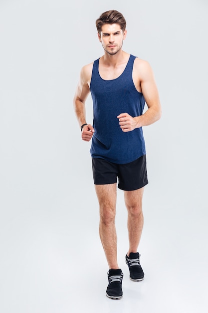 Full length portrait of a fitness man running isolated on a white background