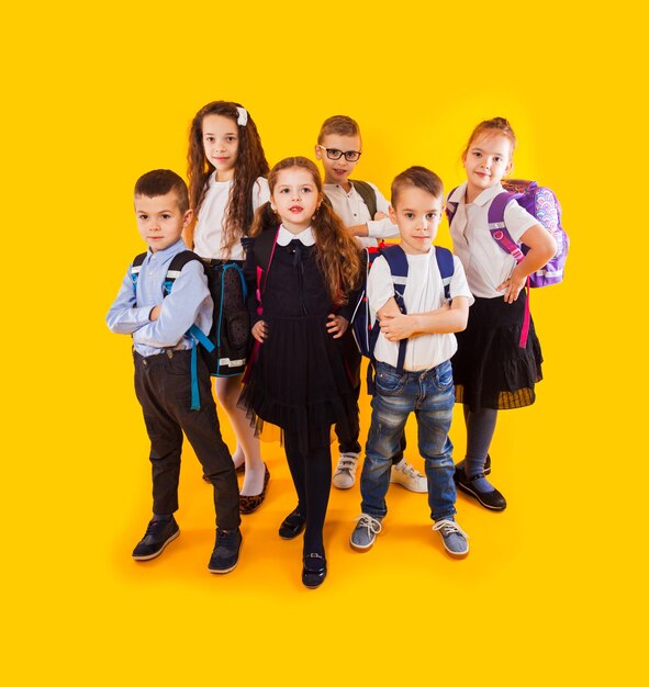 Full length portrait of friends standing against yellow background