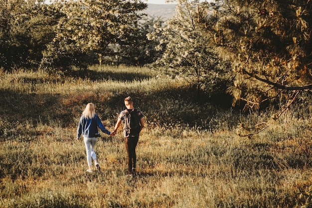 Full length portrait from back of lovely couple holding by hands and exploring new places while traveling.