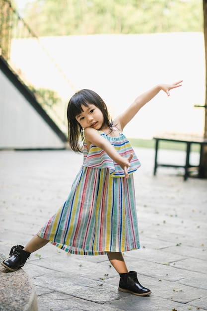 外で立っている女の子の全長の肖像画