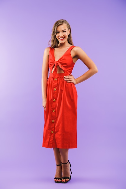 Full length portrait of gorgeous brunette woman wearing red dress smiling