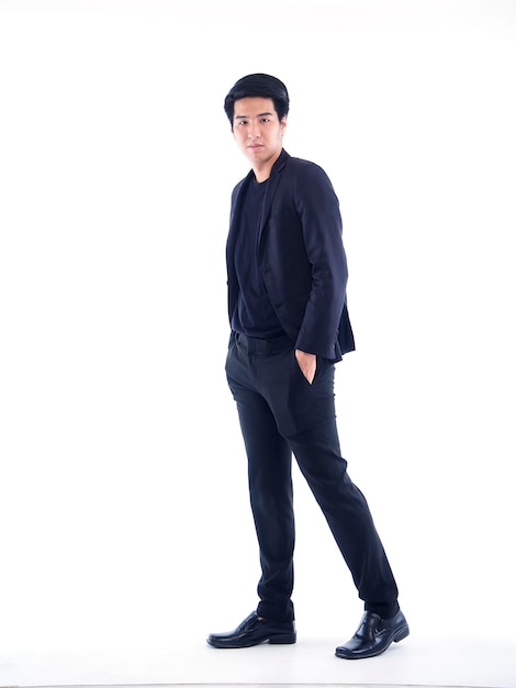 Full length portrait of handsome young man posing on white wall