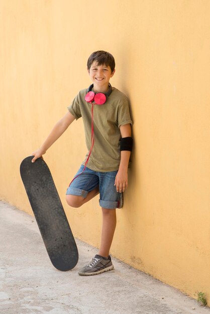 Photo full length portrait of happy boy holding umbrella against wall