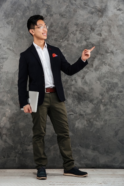 Full length portrait of a happy young asian man