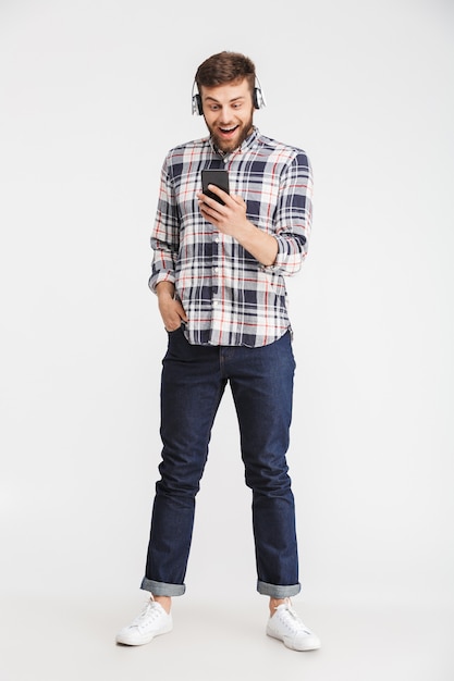 Full length portrait of a happy young man in plaid shirt