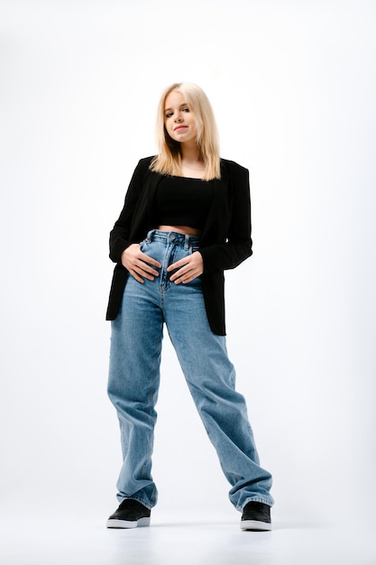 Full length portrait of hipster girl in wide jeans and black jacket