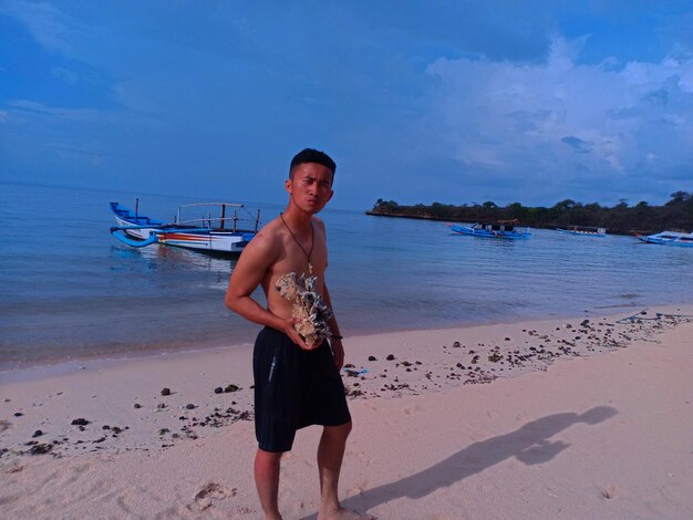 Full length portrait of man on beach against sky