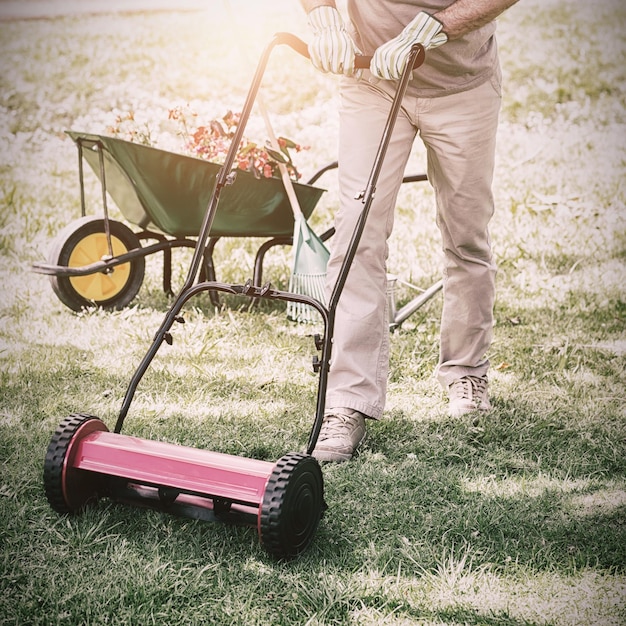 写真 芝生を刈る笑顔の男の完全な長さの肖像画