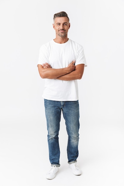 Фото Полная длина портрет красивого мужчины 30-х годов в повседневной футболке и джинсах, улыбающегося, изолированного на белом