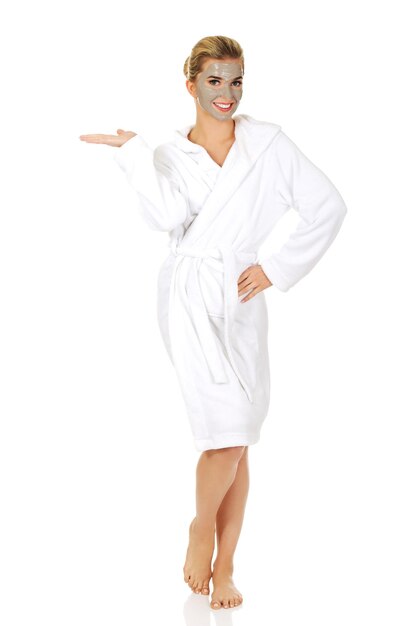 Фото Полнометражный портрет улыбающейся молодой женщины в халате, стоящей на белом фоне