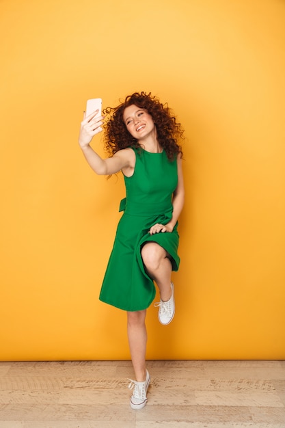 Full length portrait of a pretty redhead woman in dress