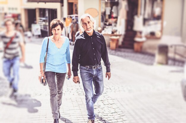 Photo full length portrait of senior man walking with woman on street in city