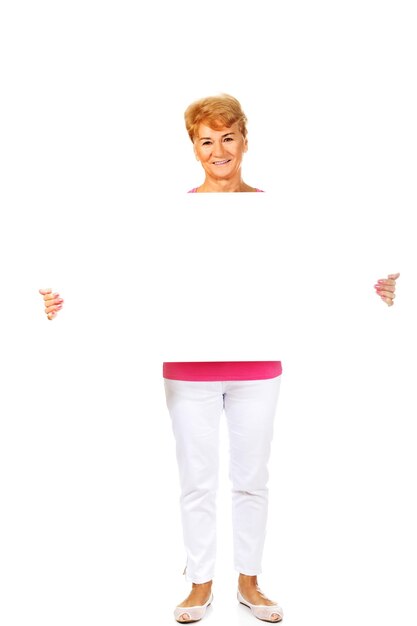 Photo full length portrait of senior woman holding blank placard on white background