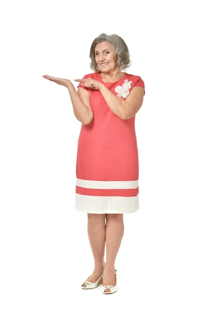 Full length portrait of senior woman pointing on white background