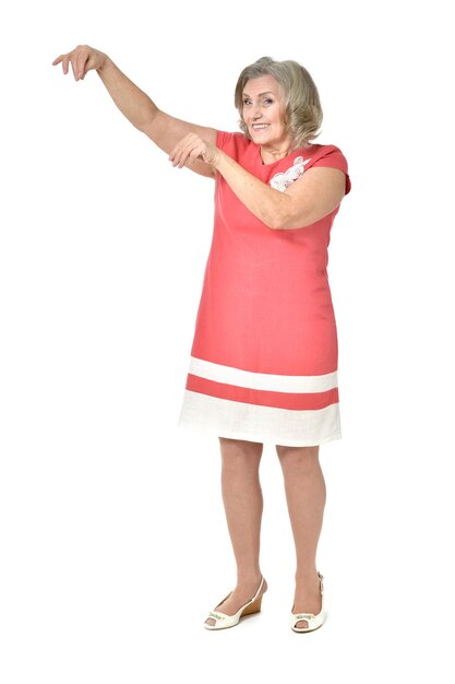 Full length portrait of senior woman pointing on white background