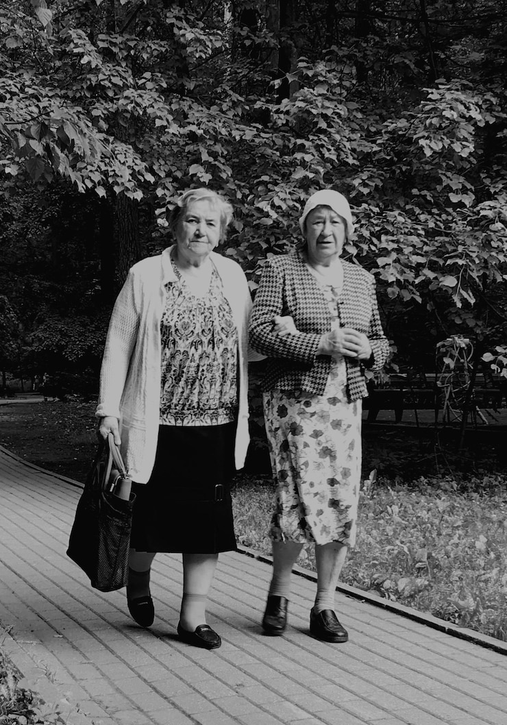Photo 公園の植物に逆らって歩いている高齢女性の全長の肖像画