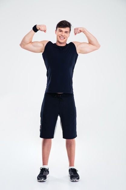 Full length portrait of a smiling man showing his biceps isolated