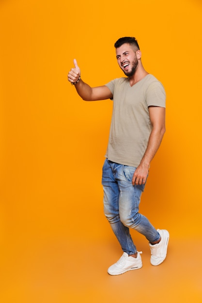 Full length portrait of a smiling young casual man