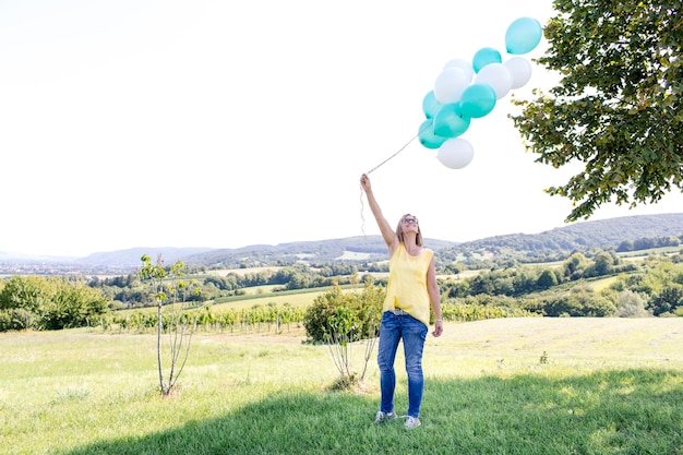 Photo full length portrait of smiling young woman standing on landscape