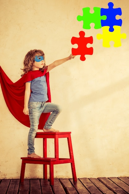 Full length portrait of superhero kid against grunge wall background