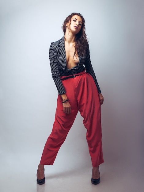 Photo full length portrait of sweet young woman in red pants in studio