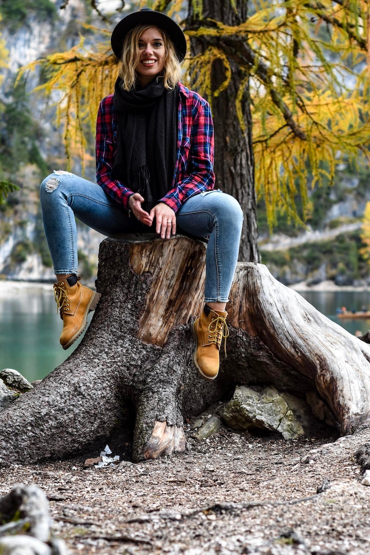 Photo full length portrait of woman sitting on tree during autumn