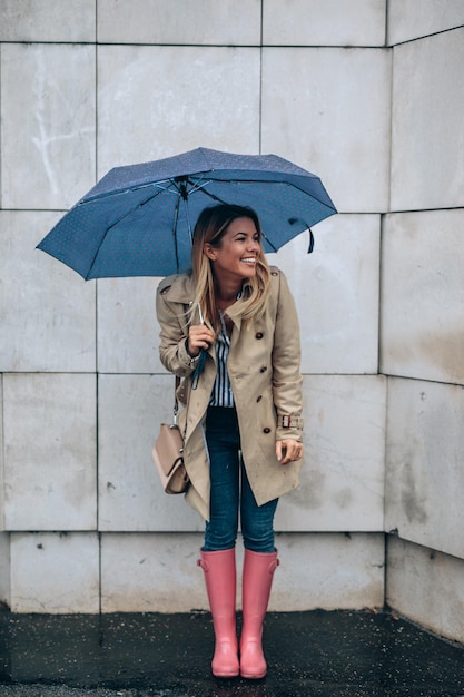 full length portrait of a woman with an umbrella outdoors in the city