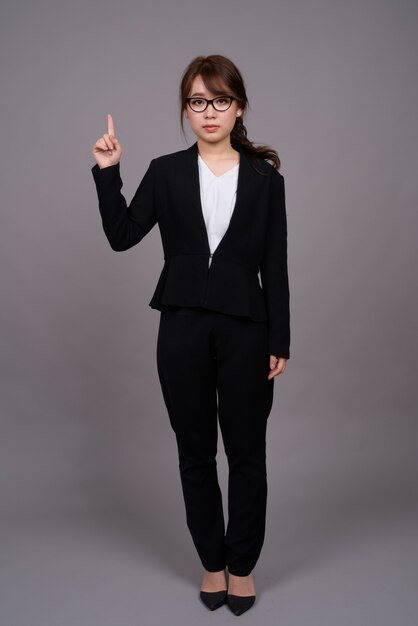 Полный портрет молодой азиатской бизнес-леди стоя