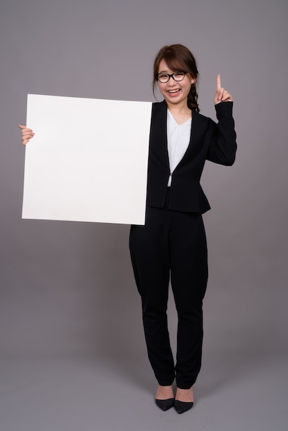 Full length portrait of young Asian businesswoman standing