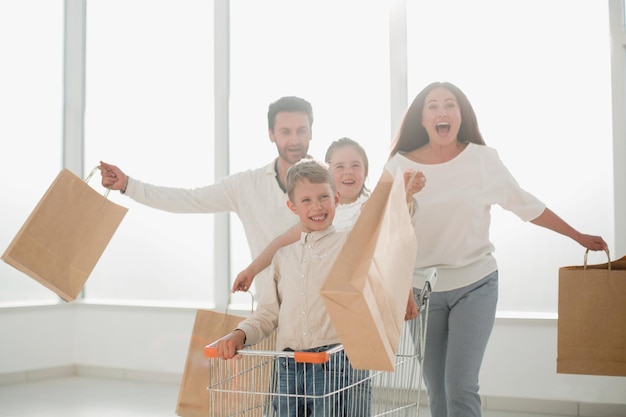 Photo full length portrait of a young family standing with shopping cartphoto with copy space