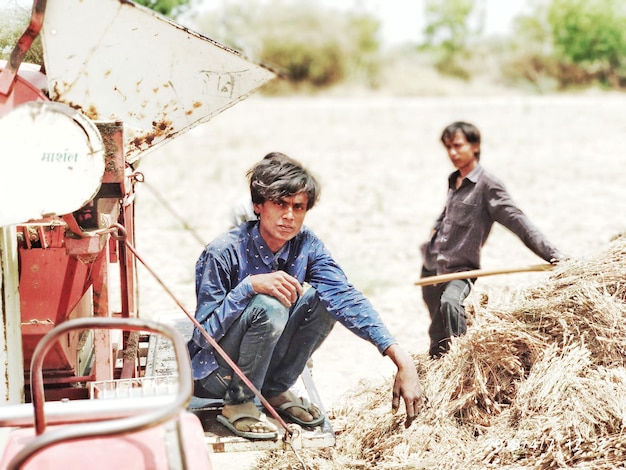 Photo full length portrait of young man sitting on tractor