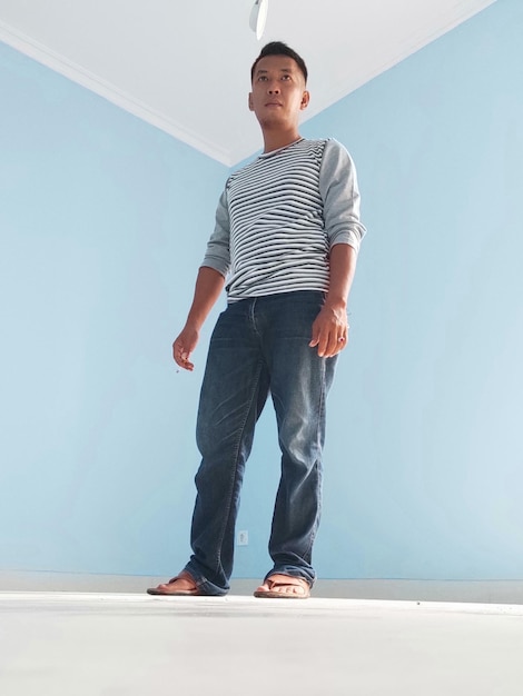 Photo full length portrait of young man standing against wall